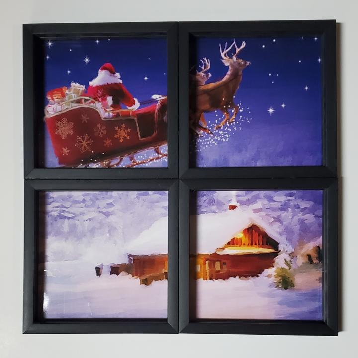 Window scene using four frames glued together with a giftbag showing santa and sleigh in the sky with a cottage on the ground. Beautiful (and Easy!) Christmas Scene using Giftbags and Frames