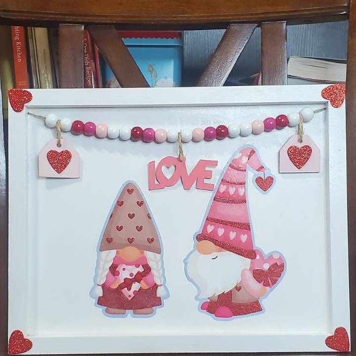 gnomes, beads, glitter hearts on twine all on white painted wooden frame board