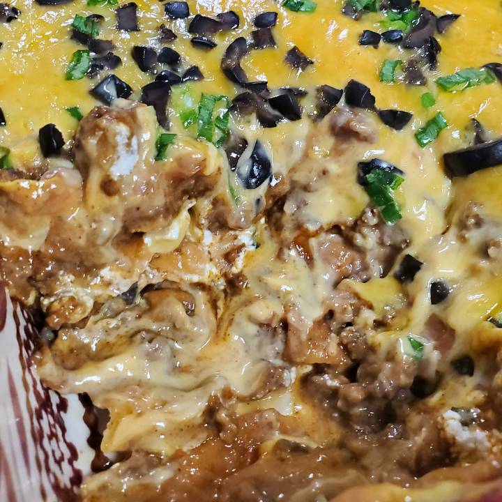 the Best Fried tortilla taco Casserole with a piece cut out of the pan.